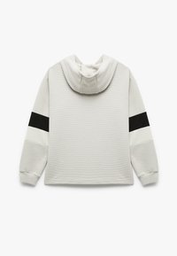 Lichtgrijze hoodie van een textuurstof, met een grote capuchon, zwart-witte horizontale strepen op de mouwen en ribgebreide manchetten.