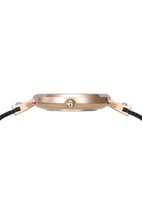 Montre ronde en or rose avec un bracelet en cuir tressé noir. Elle présente une couronne proéminente et un profil de boîtier élégant et lisse.
