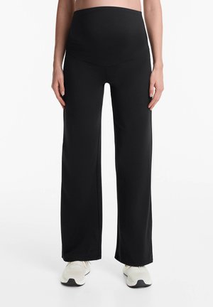 Pantaloni yoga per maternità neri con vita alta elastica e design a gamba larga, realizzati in un tessuto leggero ed elasticizzato per il massimo comfort.