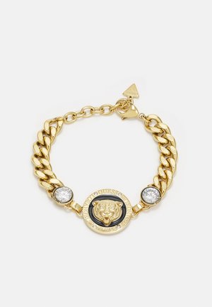 Bracelet chaîne en or avec un médaillon central tête de tigre, deux cristaux ronds transparents et un petit pendentif triangulaire près du fermoir.