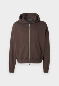 Haut à zip marron en tissu doux, avec une grande capuche, une poche kangourou à l'avant et des poignets et un ourlet côtelés.
