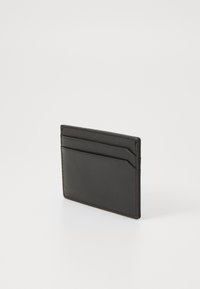 Portofel din piele neagră cu un design minimalist, având patru sloturi și margini cusute pentru durabilitate. Textură netedă, formă subțire.