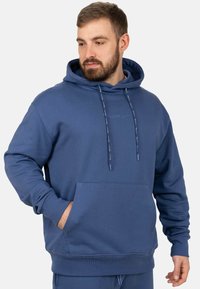 Felpa con cappuccio blu realizzata in tessuto morbido, con tasca a marsupio frontale, cordini e polsini a costine all'orlo e alle maniche.