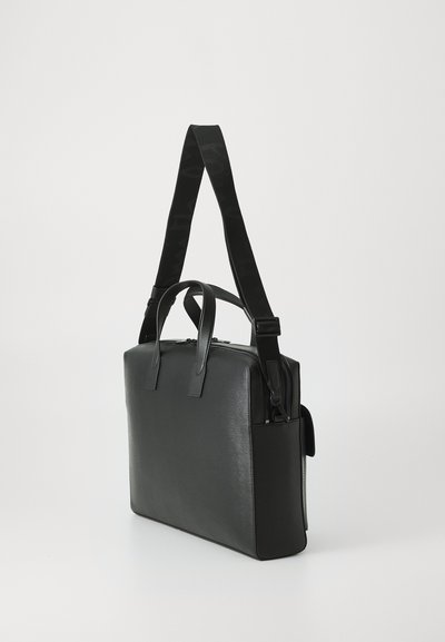 Black leather bag with two top handles, a detachable shoulder strap, and a zippered main compartment. Features a sleek, smooth texture.