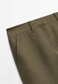 Pantalon vert olive en tissu texturé, avec devant plat, passants de ceinture et poches latérales, conçu pour une coupe ajustée.