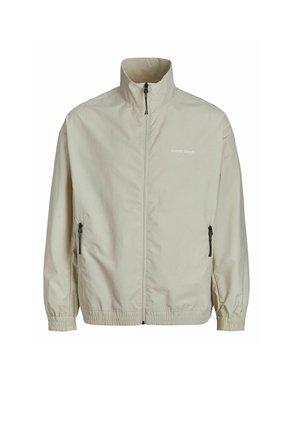 Bežna lahka jakna s stoječim ovratnikom, polnim zadrževalnikom, stranskimi žepi z zadrgo, elastičnimi manšetami in logotipom natisnjenim na prsih.