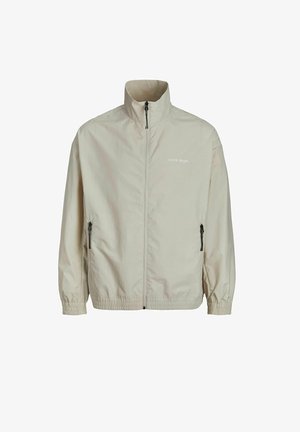 Bežna lahka jakna s stoječim ovratnikom, polnim zadrževalnikom, stranskimi žepi z zadrgo, elastičnimi manšetami in logotipom natisnjenim na prsih.