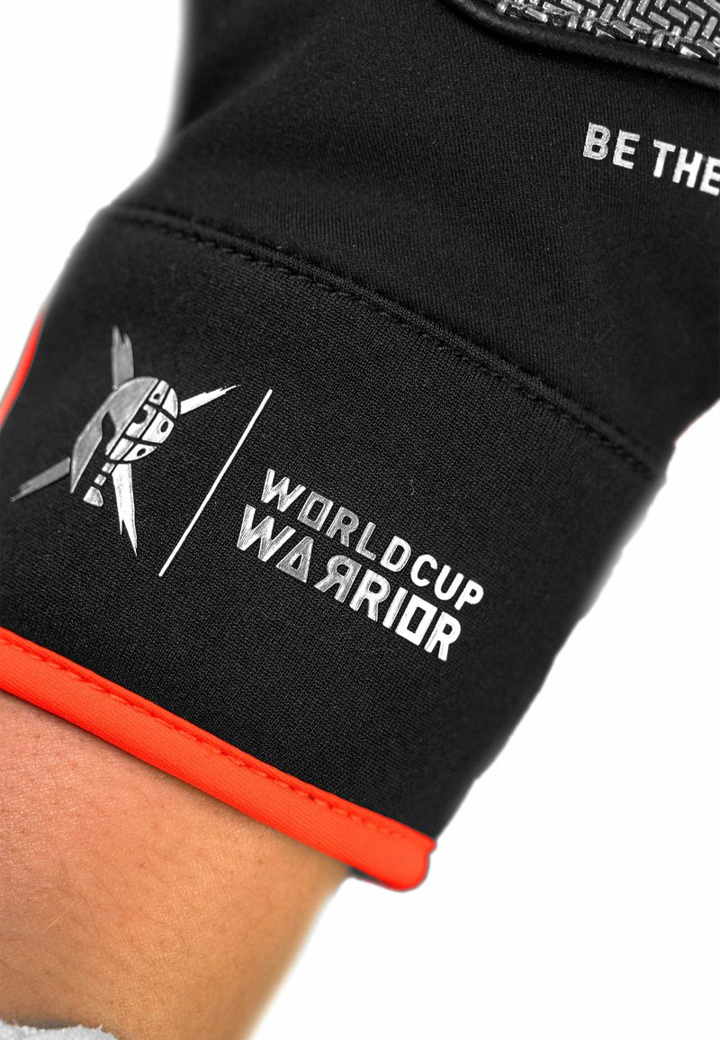 Schwarze Handschuhe mit orangefarbenen Akzenten, versehen mit einem grafischen Logo und dem weißen Text "WORLD CUP WARRIOR", aus strukturiertem, dehnbarem Stoff.