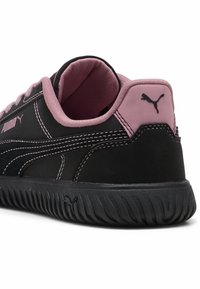 Sorte og pink Puma sneakers med en tekstureret sål, der viser bag- og sidevinklen, hvilket fremhæver brandets logo og syninger.