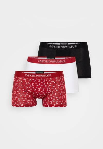 Kolme paria Emporio Armani miesten bokseria: yksi punainen, jossa on kirjainpainatus, yksi musta ja yksi valkoinen, jokaisessa brändätty elastinen vyötärö.