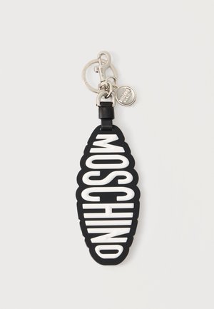 Sort nøglering med hvidt MOSCHINO-tekst i fede bogstaver, fastgjort til sølv metalclasp og mærket rund vedhæng.