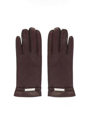 Een paar donkerbruine leren handschoenen met een klein metalen gespdetail bij de pols, plat naast elkaar gelegd op een witte achtergrond.