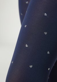 Granatowe rajstopy o gładkiej fakturze, z srebrnymi wzorami w kształcie serca rozsianymi po całej tkaninie. Elastyczny i dopasowany krój.