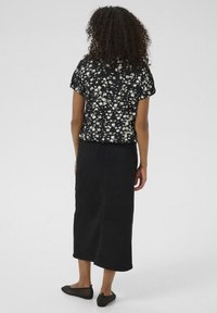Black floral blouse with short sleeves, paired with a long black denim skirt and black mesh flats. Simple design, no visible patterns on bottom.