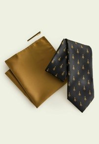 Melns kaklasaite ar zelta koka rakstu, komplektā ar zelta krāsas kabatas lakatiņu un zelta kaklasaites klipšu. Gludas tekstūras, formāls dizains.