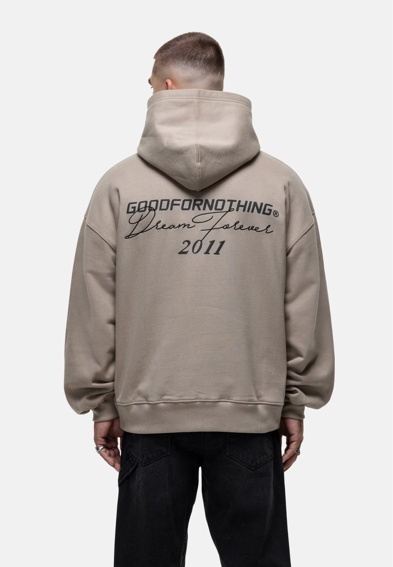 Felpa con cappuccio beige dal taglio rilassato. Presenta la scritta stampata "GOODFORNOTHING Dream Forever 2011" sul retro. Polsini e orlo a coste.