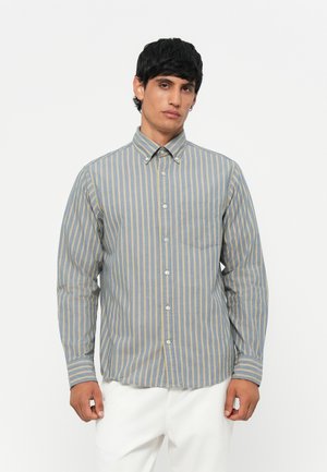 Gestreepte button-up blouse in blauwe en gele tinten. Heeft lange mouwen, een kraag en een borstzak met een relaxte pasvorm.