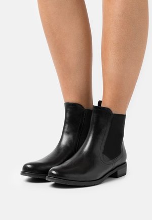 Bottes noires en cuir avec des panneaux latéraux en élastique, bouts ronds, talons bas à bloc et texture lisse. Design minimaliste sans embellissements.