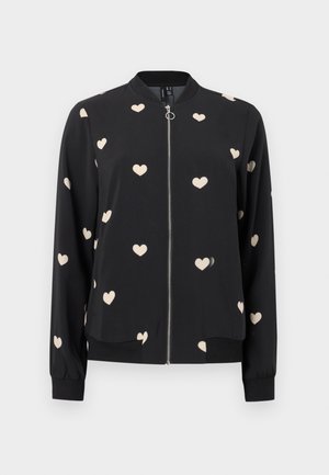 Sort bomberjakke med lynlås foran, ribbede manchetter og spredte cremehjerte-mønstre på stoffet. Blødt materiale med løs pasform.