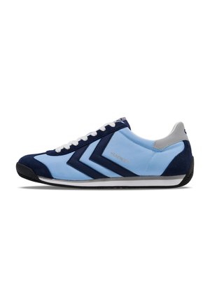 Light blue sports shoe with navy suede accents, white laces, and a textured rubber sole. Features angular design details and logo.