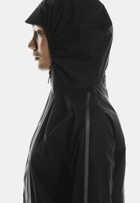 Must värvitu vihmakate, millel on sobiv kapuuts, sile tekstuur ja peene peegelduv triip külgedel nähtavuse tagamiseks.