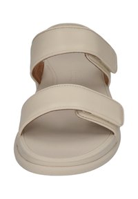 Beige sandaler med öppen tå och två breda korsade remmar, tillverkade av slät läder. Har en vadderad innersula och en enkel, rund sula.