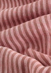 Tissu doux avec vue rapprochée de rayures horizontales roses et marron et un motif tissé texturé.