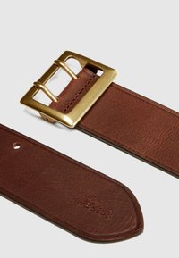 Καφέ δερμάτινη ζώνη με διπλό αγκράφα από χρυσό μέταλλο και εμφανές ανάγλυφο λογότυπο Levi's κοντά στο μυτερό άκρο.