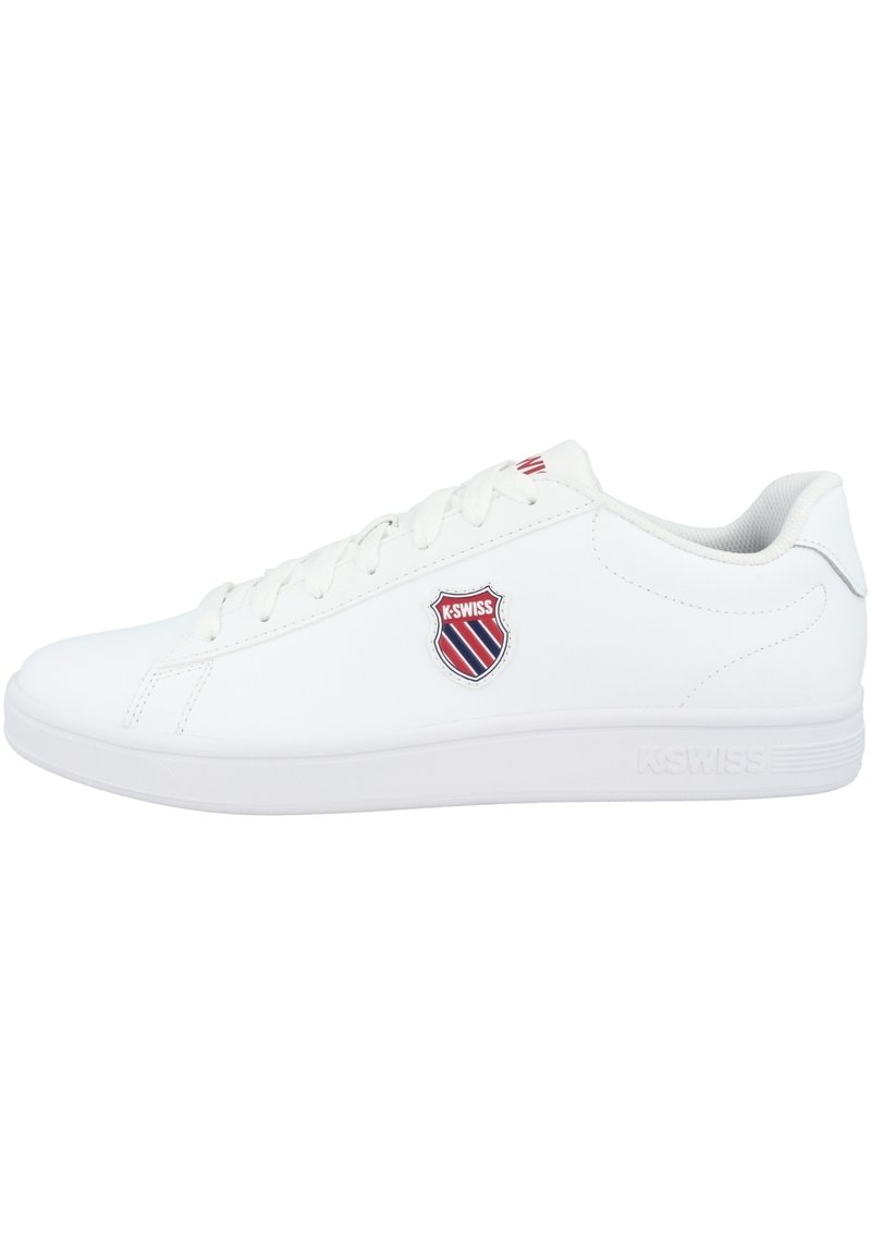 White athletic shoe with smooth synthetic upper, textured sole, six eyelets, and a stitched logo shield in color. Flat laces and padded collar.