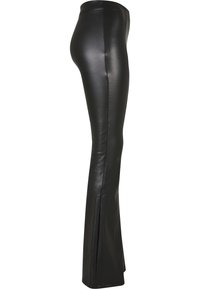 Schwarze Kunstlederhose mit leicht ausgestelltem Bein und seitlichem Nahtdetail, seitlich gezeigt.