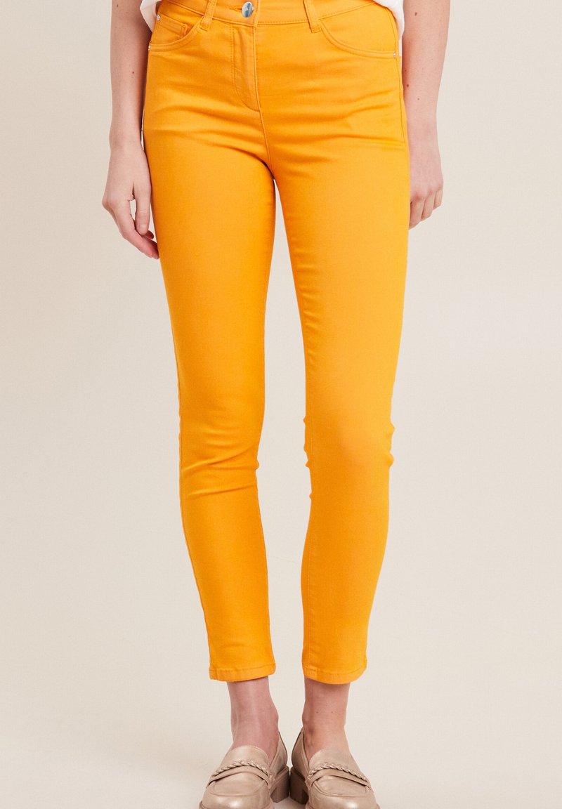 Skinny jeans in felbruin katoenmix, met een strakke pasvorm, hoge taille en klassieke vijf-pocket styling. De zoom is cropped.