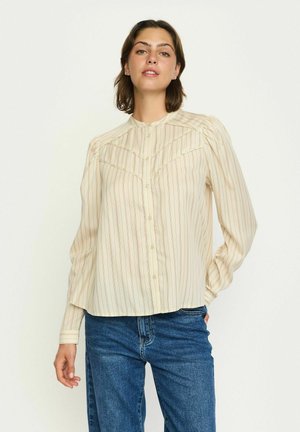 Helle beige Bluse mit vertikalen Streifen, Knopfleiste vorne, Stehkragen und plisseeartigen Details an den Schultern. Lange Ärmel, lässige Passform.