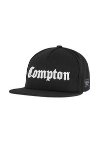 Black baseball cap with flattened visor, featuring white embroidered text "Compton." Made of fabric with a textured finish, side label visible.