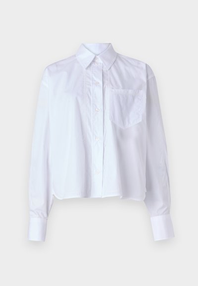 Bela skrajšana srajca iz bombaža, z gumbom na sprednji strani, z izrezanim ovratnikom, dolgimi rokavi in enim žepom na prsih. Gladka tekstura.