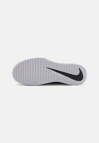 Juodas sportinis batų padas su tekstūruota pilka gumine paviršiumi, turintis iškilią juodą Nike swoosh ir zigzagų raštą, skirtą sukibimui.