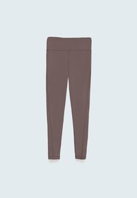 Leggings de sport marron avec une taille haute, un design ajusté, une texture lisse et des coutures plates, présentés sur un fond bleu clair.