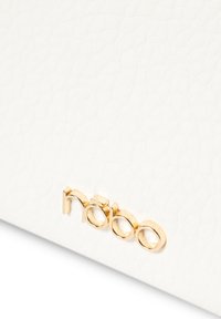 Witte gestructureerde leren handtas met een goudkleurig logo-detail aan de voorkant, dat de nadruk legt op een gladde oppervlakte en moderne designelementen.