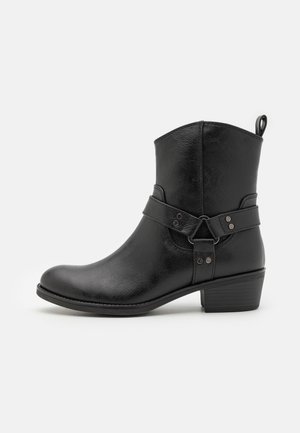 Bottines noires en cuir synthétique texturé, avec une sangle latérale et des accents métalliques, et un talon empilé bas.