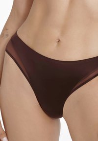 Brown bikini bottom with a smooth fabric and sheer mesh accents along the sides, featuring a low-rise design and clean lines.