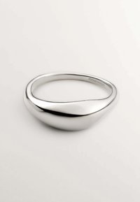 Brazalete de plata con un diseño suave y redondeado, que presenta una superficie pulida y una forma asimétrica, creando una apariencia elegante.