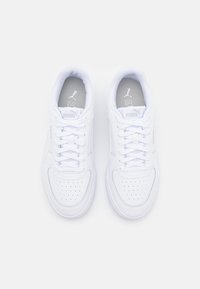 Bílé sportovní tenisky s perforovanou špičkou, hladkým koženým svrškem, plochými tkaničkami a polstrovaným límcem. Na jazyku a boku mají logo.