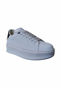 Sneaker bianca con tomaia sintetica liscia, punta rotonda, lacci piatti e suola spessa. Presenta un accento nero sul tallone.