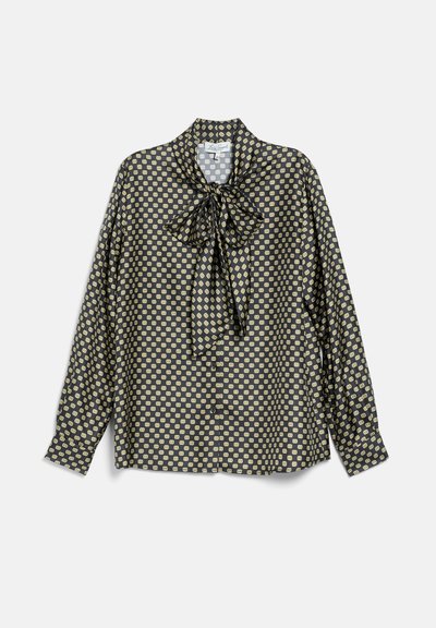 Blouse noire à manches longues avec un petit motif géométrique jaune et un nœud noué au col, boutonnée devant, manches à poignets.