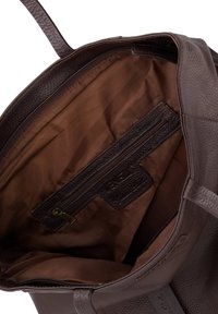 Braune Ledertragetasche mit strukturierter Außenseite, innen tiefbraunem Stofffutter, Reißverschlusstasche und stabilen Griffen.