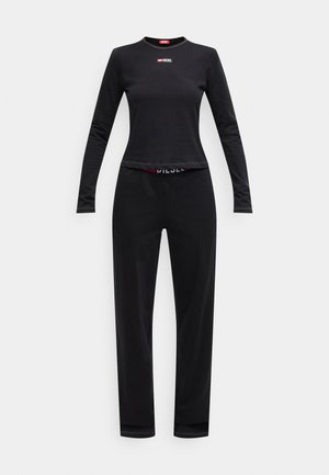Schwarzes Langarmoberteil und passende Hose aus glattem Stoff. Das Oberteil hat ein kleines rotes "Diesel"-Logo auf der Brust, die Hose hat einen Logo-besetzten Bund.