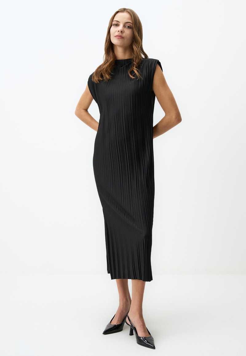 Robe noire plissée avec un col montant et des manches courtes. Tissu lisse et léger avec des plis verticaux ; coupe midi.