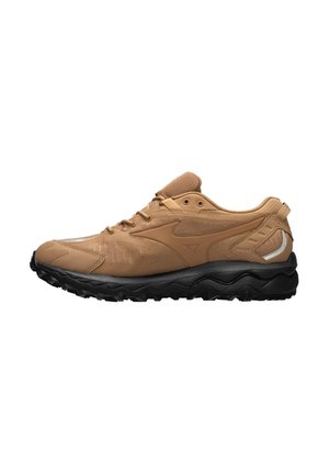 Tan-farbener Sportschuh mit strukturiertem Obermaterial, Netzdetails und einer robusten schwarzen Laufsohle. Enthält ein Logo und reflektierende Akzente an der Seite.