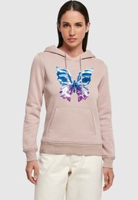 Felpa leggermente rosa con una grande grafica di una farfalla blu e viola sul davanti. Presenta una tasca frontale e un cappuccio con cordino. Tessuto morbido.