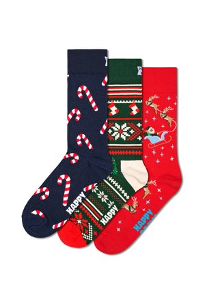 Drei Paar Socken: marineblau mit Zuckerstangen, grün mit festlichen Mustern und rot mit Rentieren, aus einem weichen Stoff gefertigt.