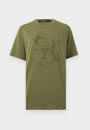 Λαδί κοντομάνικο T-shirt με γεωμετρικό πορτρέτο γραμμικής τέχνης ενός ατόμου με γυαλιά ηλίου και ψηλό γιακά.